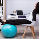 Woman at her desk having a chair and a yoga ball (her feet are propped up on the particular yoga ball)